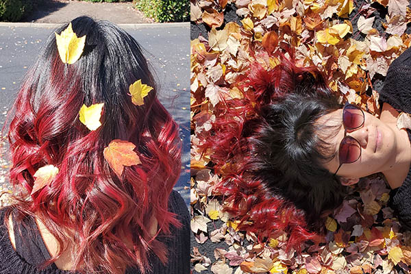 Red Head girl posing with autum leaves after having her hair colored by Mary Keeling